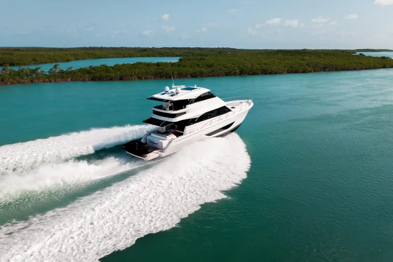 Slide: The Image of 2024 Maritimo M55 yacht cruising on turquoise waters, surrounded by lush greenery. - 4