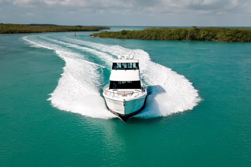 Slide: The Image of 2024 Maritimo M55 yacht cruising on turquoise waters, leaving a wake behind. - 5