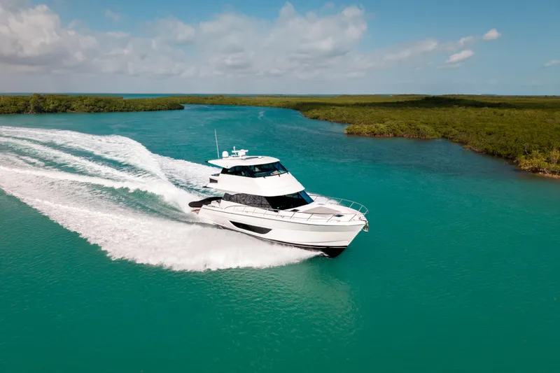 Slide: The Image of 2024 Maritimo M55 yacht cruising on turquoise waters under a clear sky. - 6