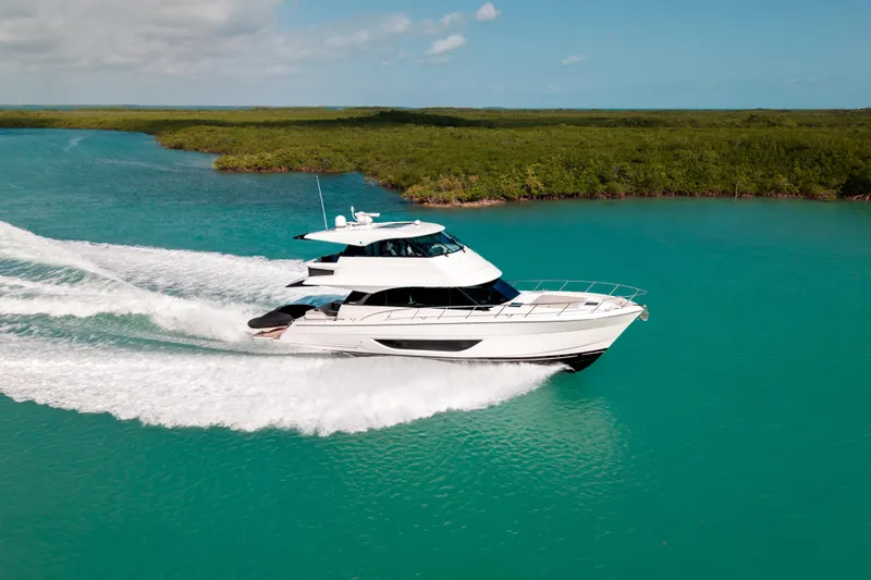 Slide: The Image of 2024 Maritimo M55 yacht cruising on turquoise water, surrounded by lush greenery. - 7