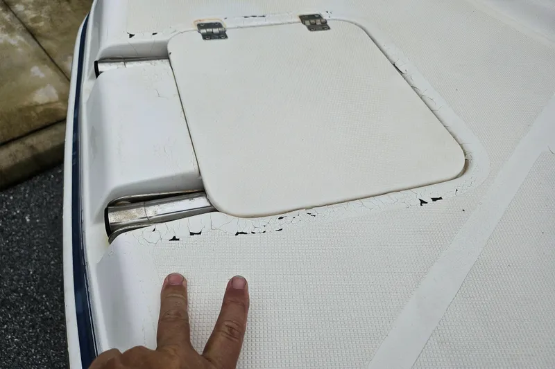 Slide: The Image of 2006 Hurricane SunDeck 237 OB boat deck with visible wear and peeling paint. - 13