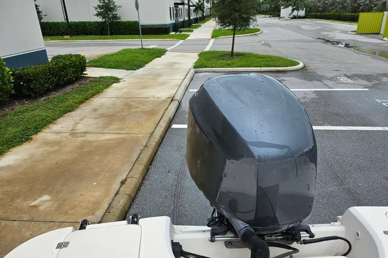 Slide: The Image of 2006 Hurricane SunDeck 237 OB boat engine in a parking lot, wet from rain. - 17