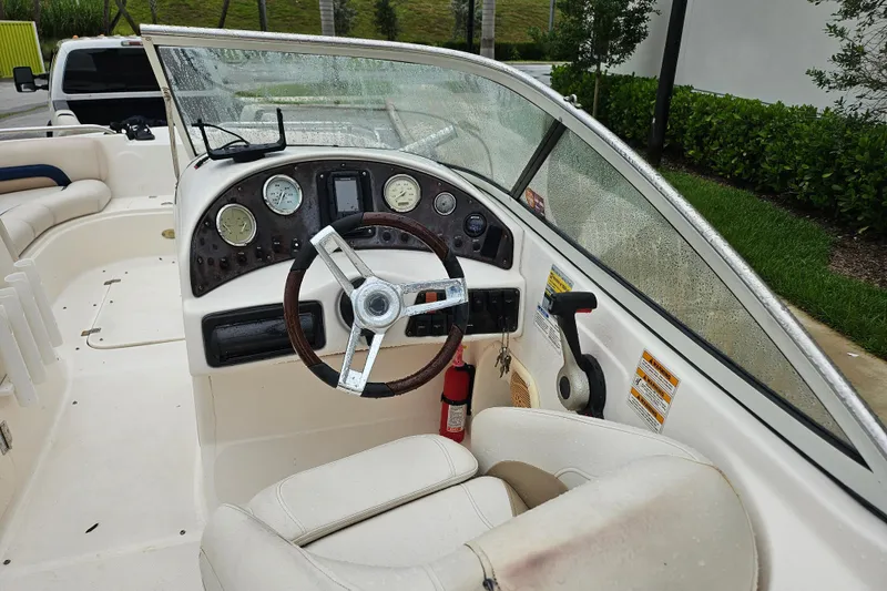 Slide: The Image of 2006 Hurricane SunDeck 237 OB boat interior with steering wheel and dashboard controls. - 18