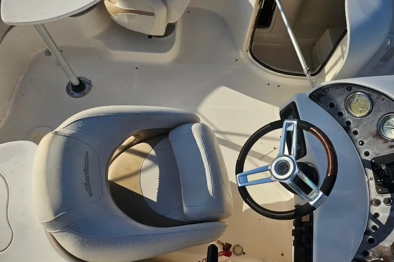 Slide: The Image of 2006 Hurricane SunDeck 237 OB boat interior with steering wheel and seating. - 28