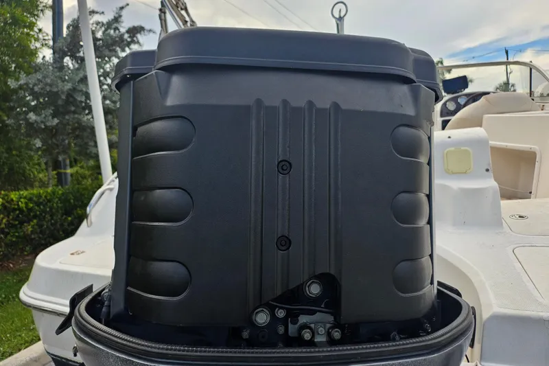 Slide: The Image of 2006 Hurricane SunDeck 237 OB boat engine close-up, showcasing black casing and deck details. - 7