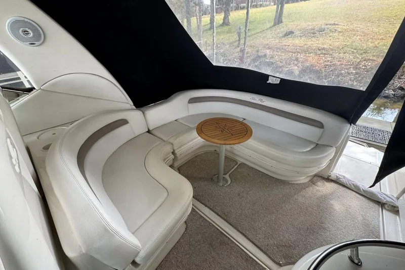 Slide: The Image of 2005 Sea Ray 340 Sundancer interior with curved seating and wooden table. - 10