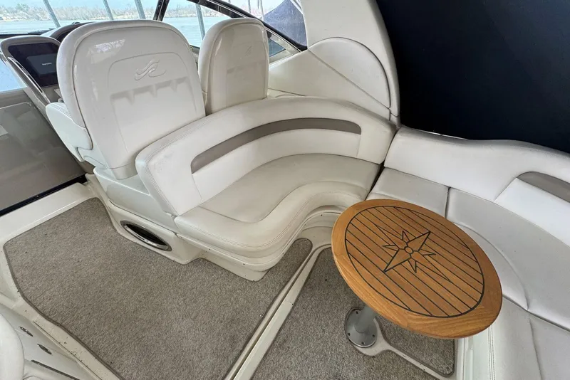Slide: The Image of Interior of 2005 Sea Ray 340 Sundancer with white seating and wooden table. - 13