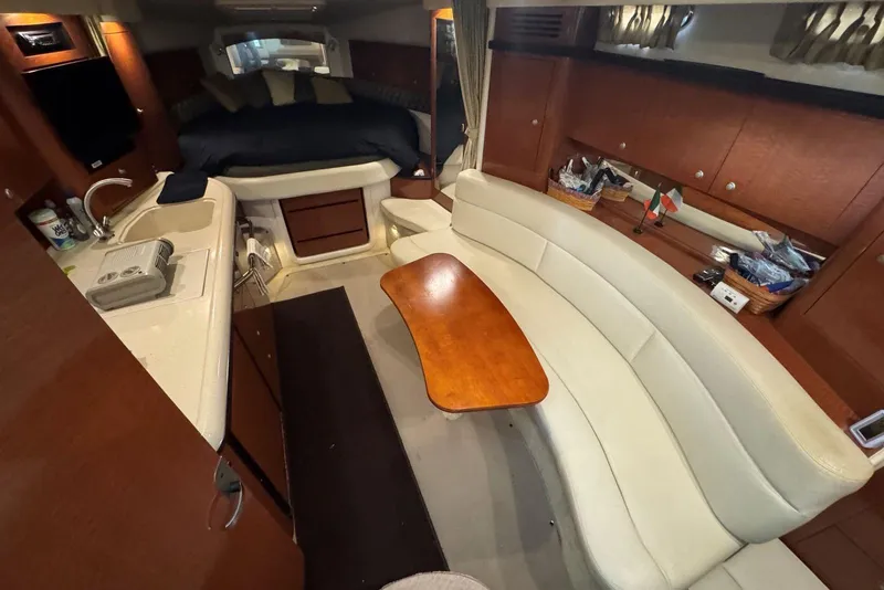 Slide: The Image of 2005 Sea Ray 340 Sundancer cabin interior with kitchen, seating, and bed. - 22