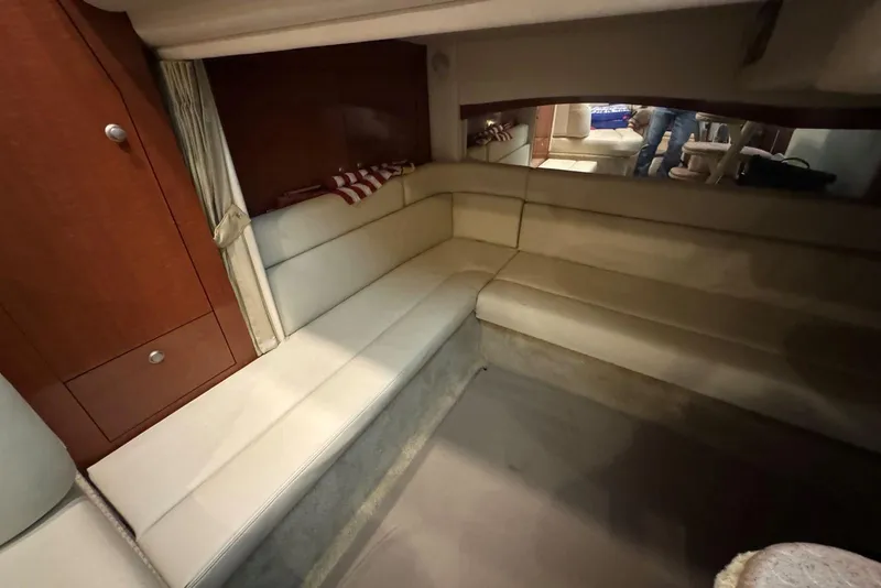 Slide: The Image of 2005 Sea Ray 340 Sundancer cabin interior with beige seating and wooden cabinetry. - 36