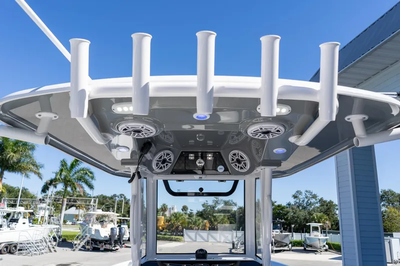 Slide: The Image of 2026 Sportsman Open 252 Center Console boat with rod holders and speakers under T-top. - 21