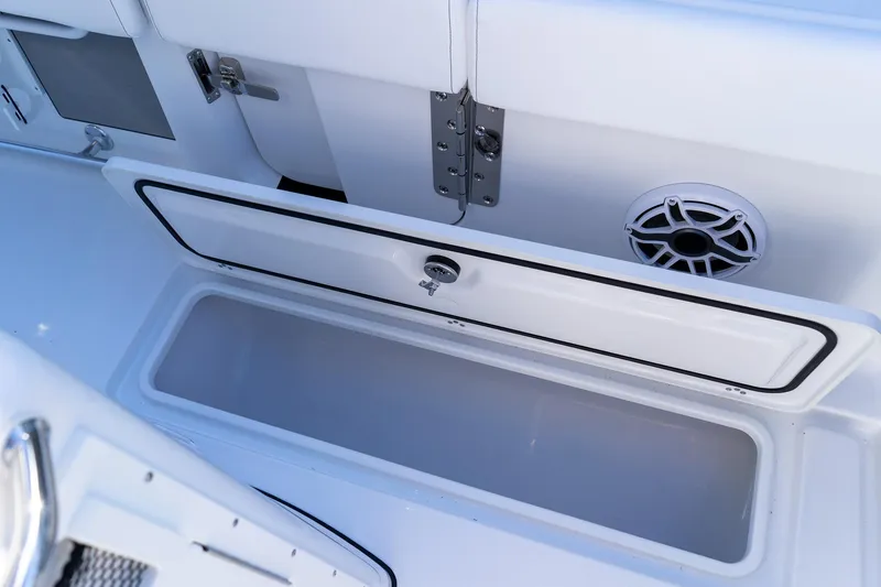 Slide: The Image of 2026 Sportsman Open 252 Center Console storage compartment with open lid and speaker. - 25