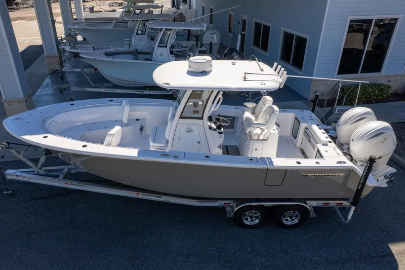 Slide: The Image of 2026 Sportsman Open 252 Center Console boat on trailer, parked near building. - 4