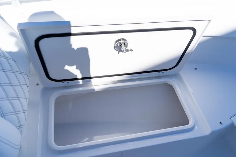 Slide: The Image of 2026 Sportsman Open 252 Center Console storage compartment with key lock, open and empty. - 42