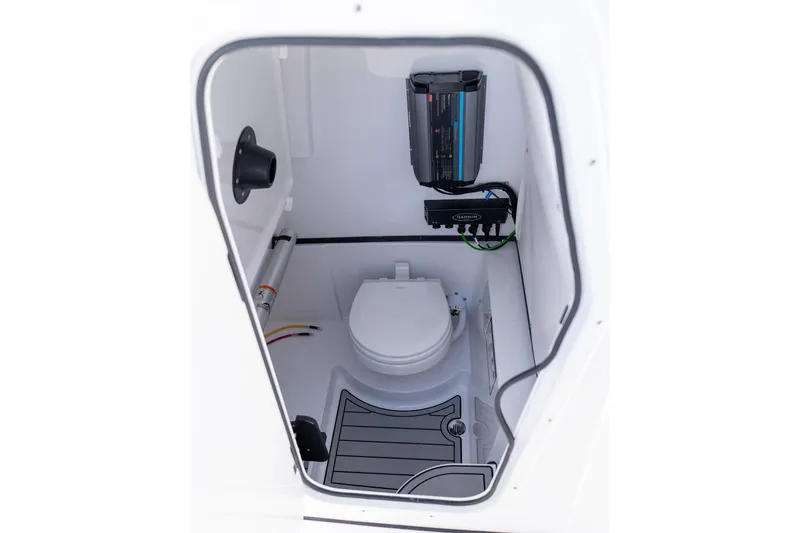 Slide: The Image of Interior of 2026 Sportsman Open 252 Center Console boat, featuring a compact marine toilet. - 50
