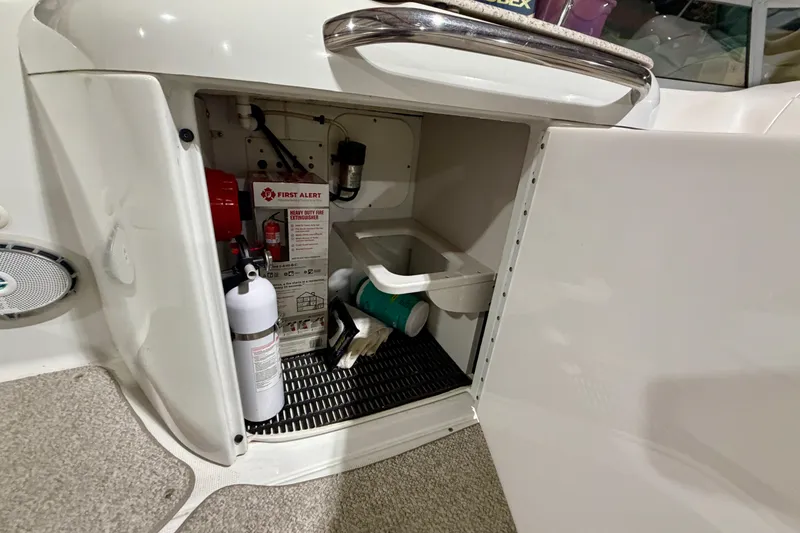 Slide: The Image of Storage compartment on a 2004 Formula 260 Bowrider with fire extinguisher and safety equipment. - 10
