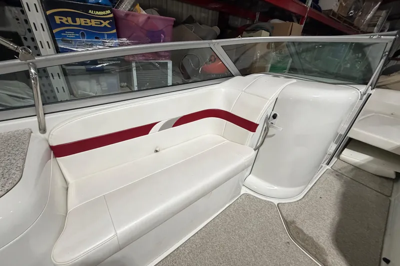 Slide: The Image of 2004 Formula 260 Bowrider interior with white seating and red accents, stored indoors. - 12