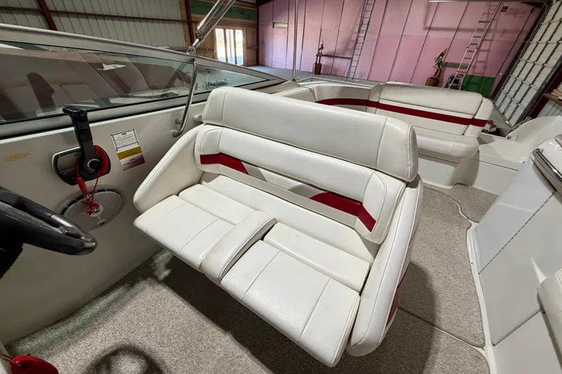 Slide: The Image of 2004 Formula 260 Bowrider interior with white and red seating in a storage facility. - 13