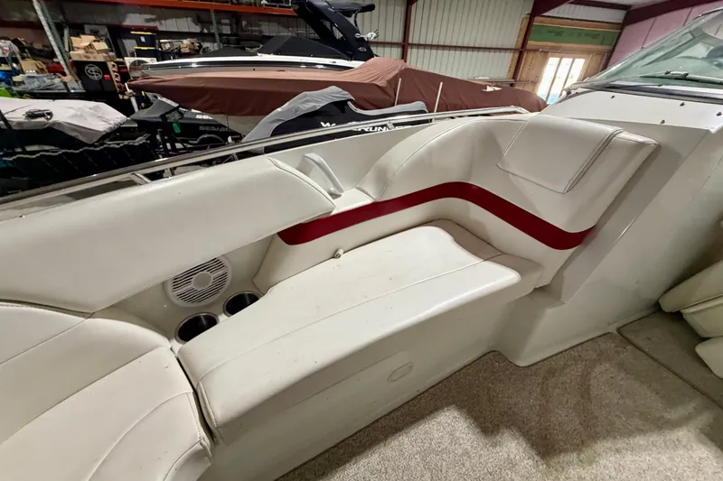 Slide: The Image of 2004 Formula 260 Bowrider interior with white seating and red accent in a storage facility. - 24