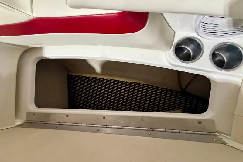 Slide: The Image of 2004 Formula 260 Bowrider interior storage compartment with cup holders and red trim. - 26