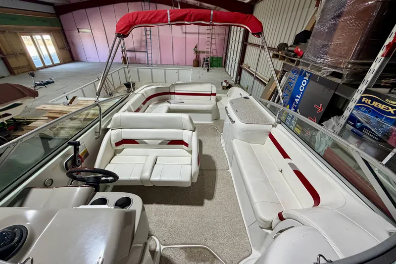 Slide: The Image of 2004 Formula 260 Bowrider interior with white and red seating in a storage facility. - 29