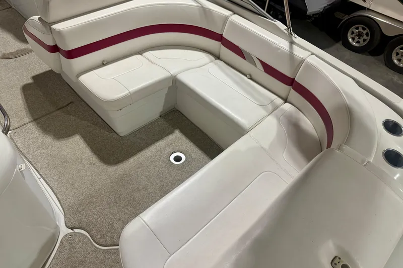 Slide: The Image of 2004 Formula 260 Bowrider interior with white and red seating, carpeted floor, and cup holders. - 7