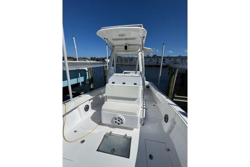 Slide: The Image of 2007 Conch 27 boat docked, showcasing spacious deck and clear blue sky. - 11
