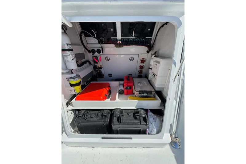 Slide: The Image of Open storage compartment on 2007 Conch 27 boat, containing safety and maintenance equipment. - 14