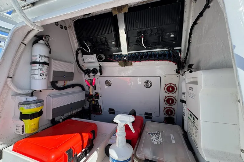 Slide: The Image of Storage compartment in a 2007 Conch 27 boat with organized toolboxes and equipment. - 16