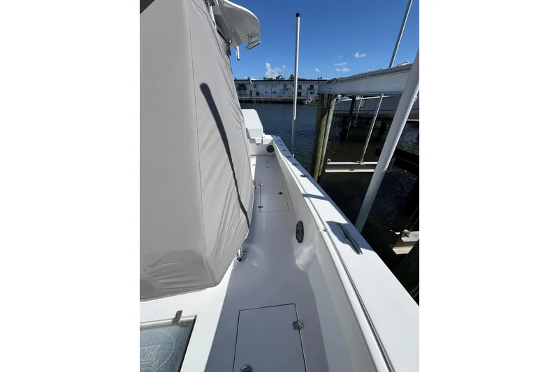 Slide: The Image of 2007 Conch 27 boat docked, featuring sleek white design and spacious seating under clear blue sky. - 19