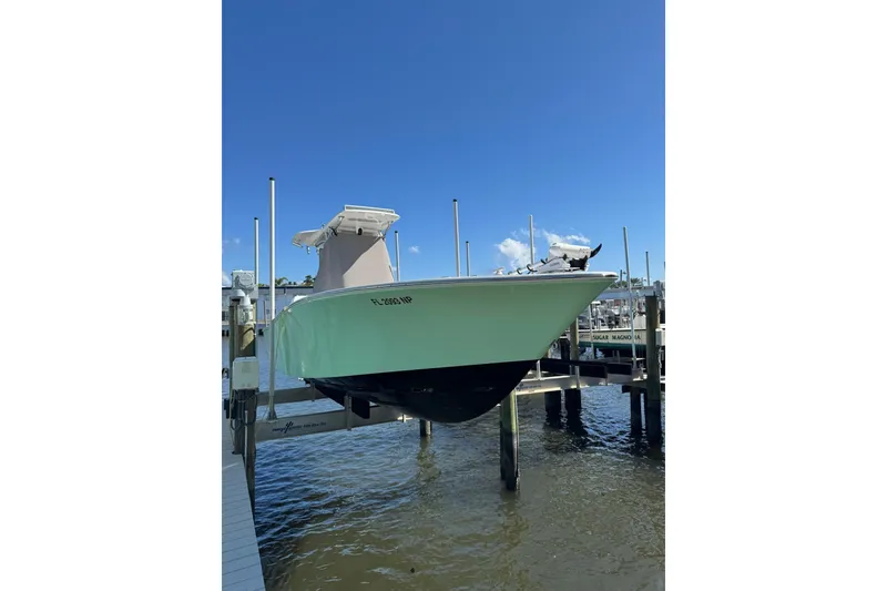 Slide: The Image of 2007 Conch 27 boat on lift, docked by the water under clear blue sky. - 26