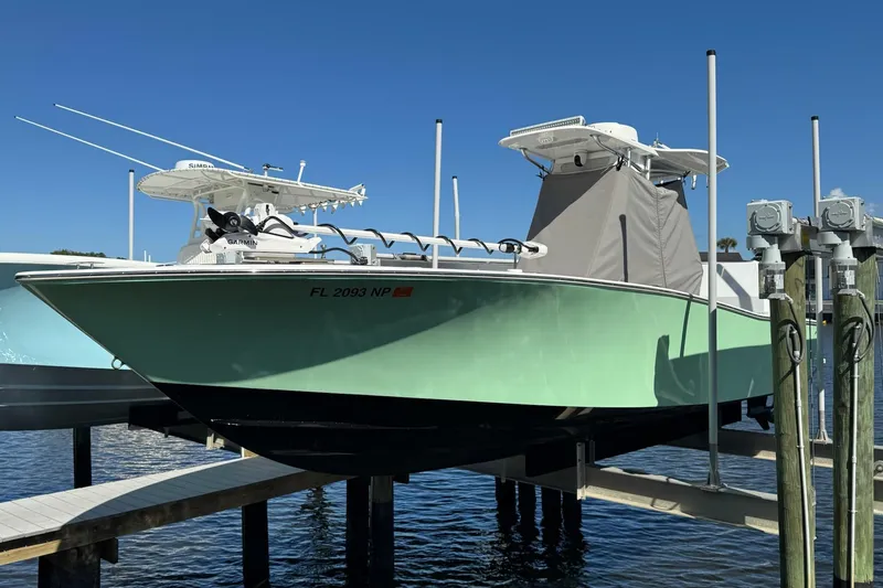 Slide: The Image of 2007 Conch 27 boat on lift against clear blue sky. - 27