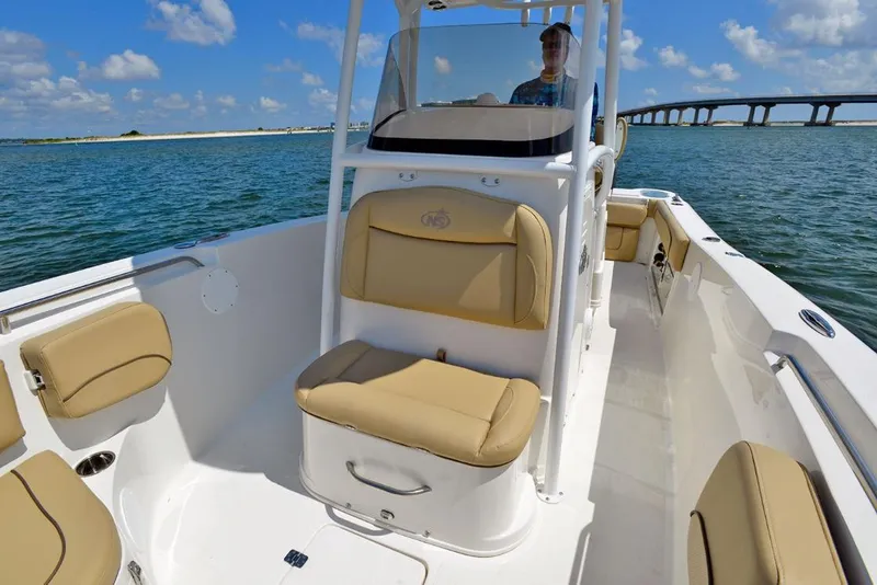 Slide: The Image of Manufacturer Provided Image: 2020 NauticStar 25 XS Offshore boat interior with tan seating, on the water near a bridge. - 8
