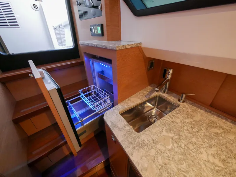 Slide: The Image of 2020 Ocean Alexander 45 Divergence Sport yacht interior with sink and open mini fridge. - 32