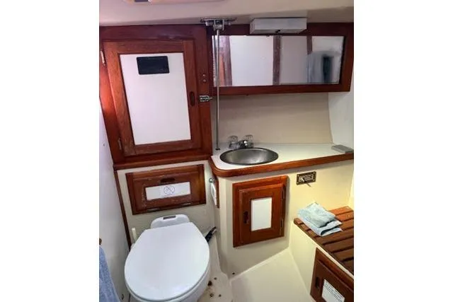 Slide: The Image of 1986 Catalina 36 yacht bathroom with wooden cabinets, sink, and toilet. - 10