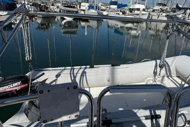 Slide: The Image of 1986 Catalina 36 sailboat docked in marina with inflatable dinghy and Mercury outboard motor. - 12