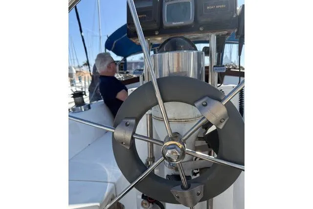 Slide: The Image of Steering wheel of 1986 Catalina 36 sailboat with person seated in the background. - 15