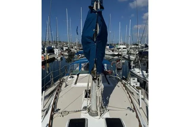 Slide: The Image of 1986 Catalina 36 sailboat docked in a marina, surrounded by other boats. - 18