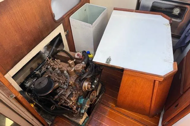 Slide: The Image of Engine compartment of a 1986 Catalina 36 sailboat, showcasing the engine and wooden cabinetry. - 19
