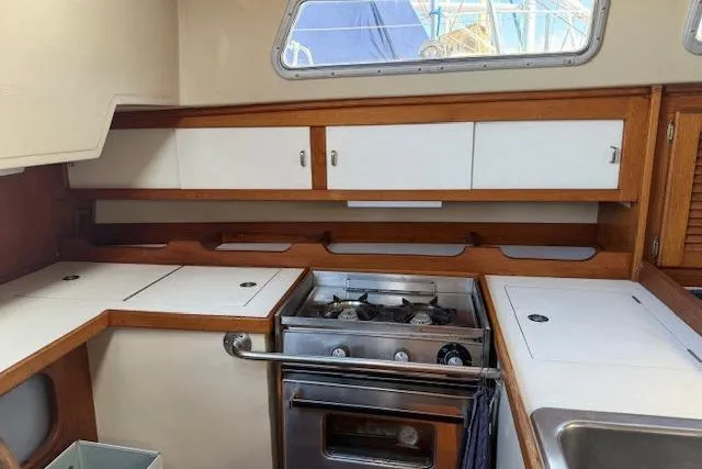 Slide: The Image of 1986 Catalina 36 yacht kitchen with stove, wooden cabinets, and countertop. - 3