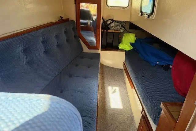 Slide: The Image of Interior of 1986 Catalina 36 sailboat with blue cushioned seating and storage. - 9