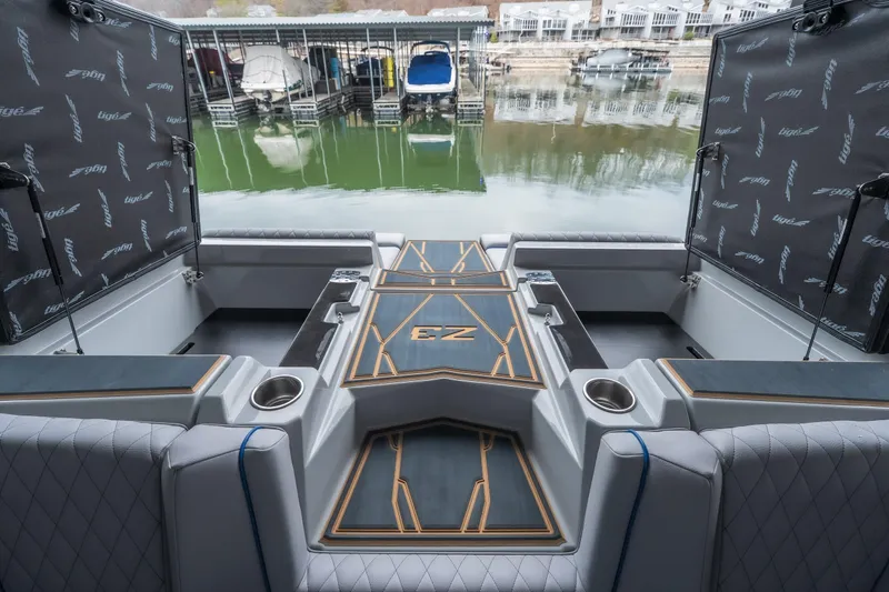 Slide: The Image of 2026 Tigé Z3 boat interior with luxurious seating and storage, docked by a marina. - 22