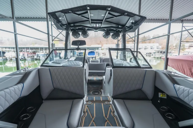 Slide: The Image of 2026 Tigé Z3 boat interior with modern seating and sleek design in a marina setting. - 28