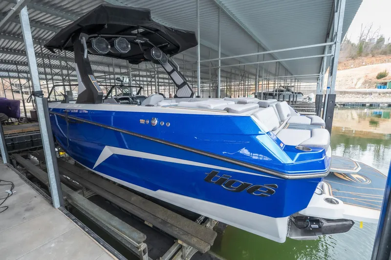 Slide: The Image of 2026 Tigé Z3 boat in vibrant blue, docked under a covered marina. - 31