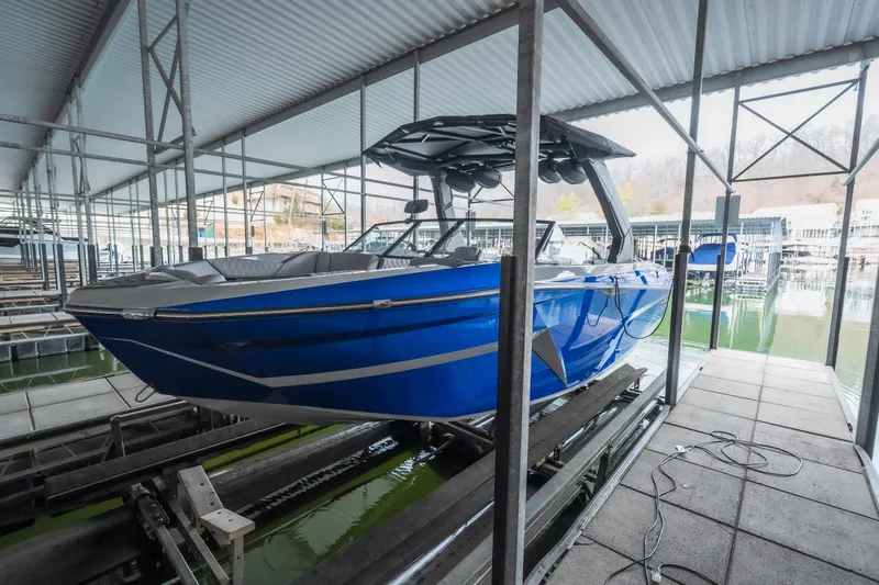 Slide: The Image of 2026 Tigé Z3 boat in blue, docked in a covered marina. - 33