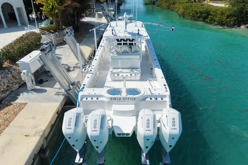 Slide: The Image of 2023 Invincible 46 Catamaran docked in clear turquoise water, rear view. - 11