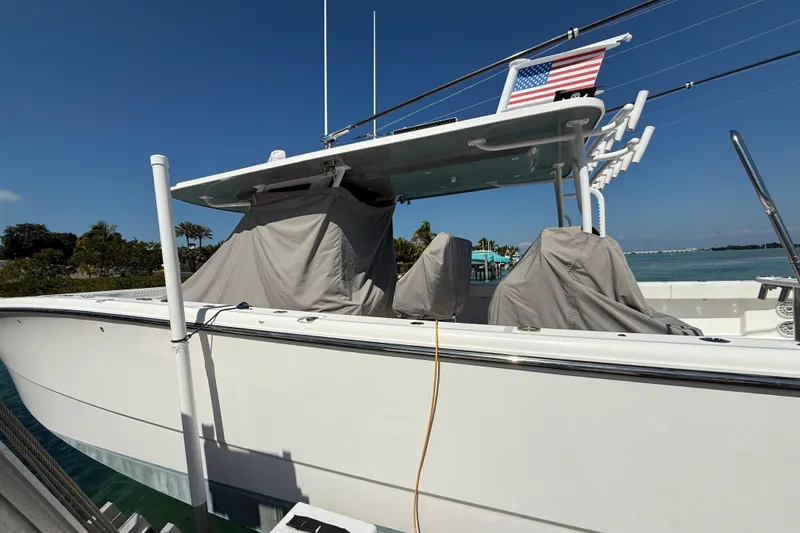Slide: The Image of 2023 Invincible 46 Catamaran docked, covered seats, American flag, sunny day. - 16