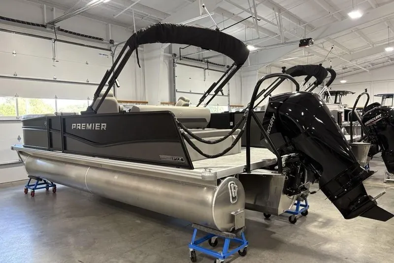 Slide: The Image of 2026 Premier 220 Sunscape RL - CL pontoon boat in showroom with Mercury outboard motor. - 2