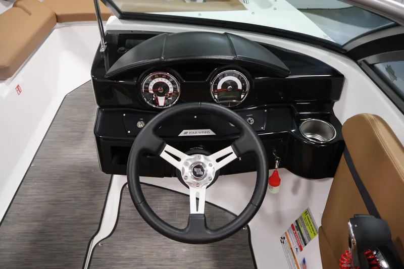 Slide: The Image of 2026 Four Winns HD2 OB boat dashboard with steering wheel and gauges. - 21