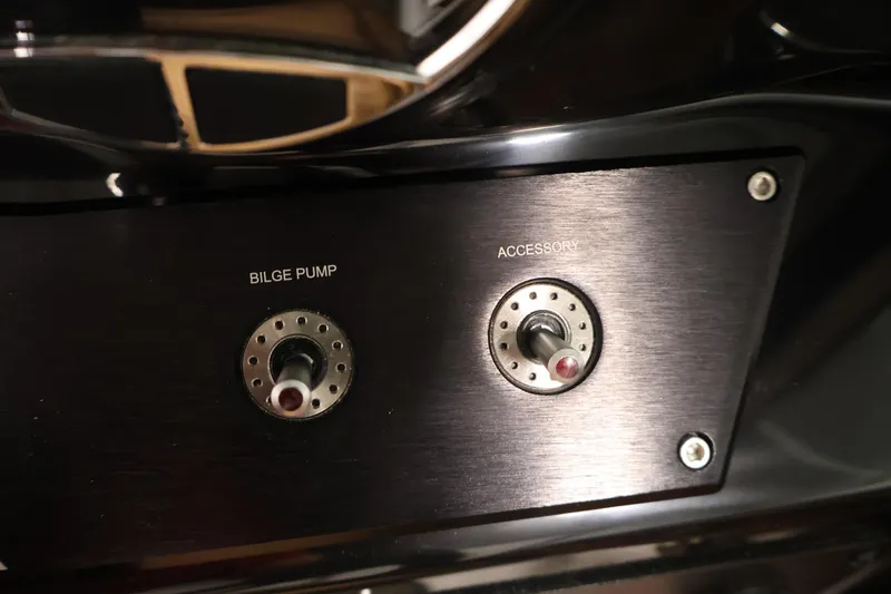Slide: The Image of Control panel of 2026 Four Winns HD2 OB boat with bilge pump and accessory switches. - 25