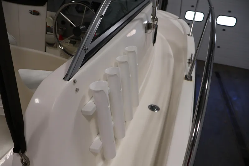 Slide: The Image of 2004 Trophy 2002 Walkaround boat interior with rod holders and steering wheel. - 17